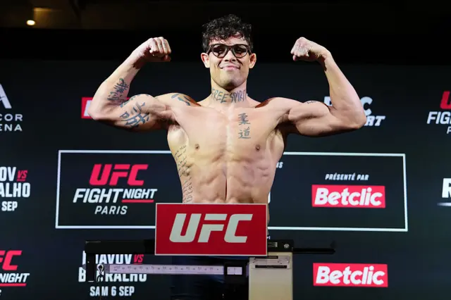 Caio Borralho on the scales flexing his biceps