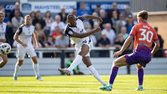 Nicke Kabamba swings his leg after striking the ball (left) to score