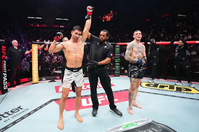 Axel Sola has his hand raised by Herb Dean