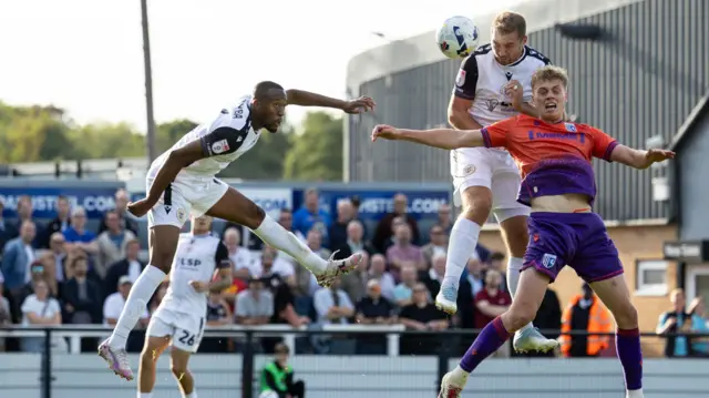 Michael Cheek (second right) heads the ball while jumping