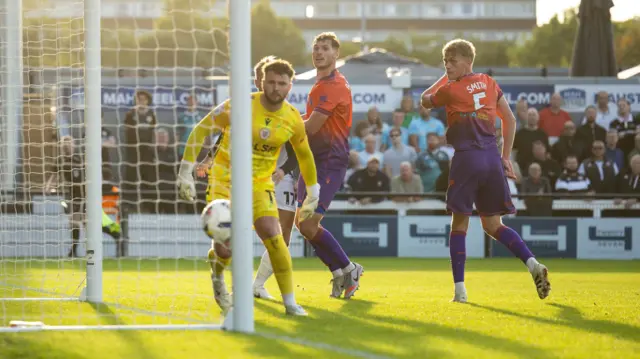 Players look as the ball flies into the goal
