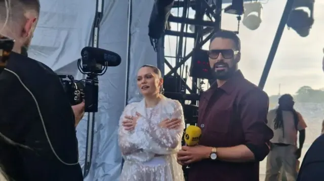 Jessie J and Rylan Clark stand together backstage ready to do an interview.