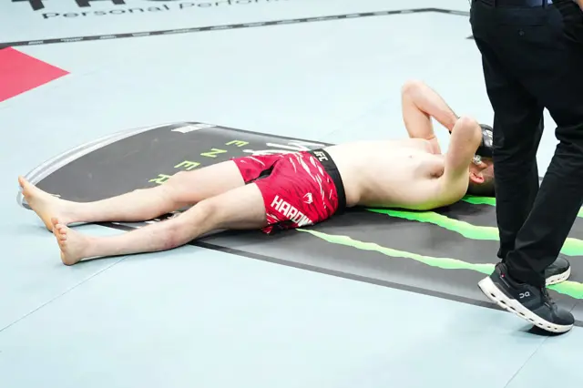 Harry Hardwick laying on the canvas with his hands on his head