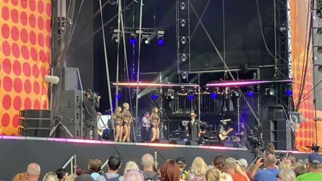 Kid Creole & The Coconuts perform on stage. Dancers can be seen moving around singer Kid Creole.