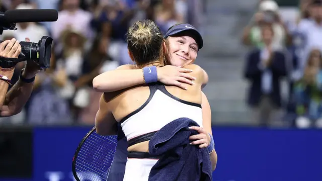Belarus's Aryna Sabalenka (L) hugs USA's Amanda Anisimova
