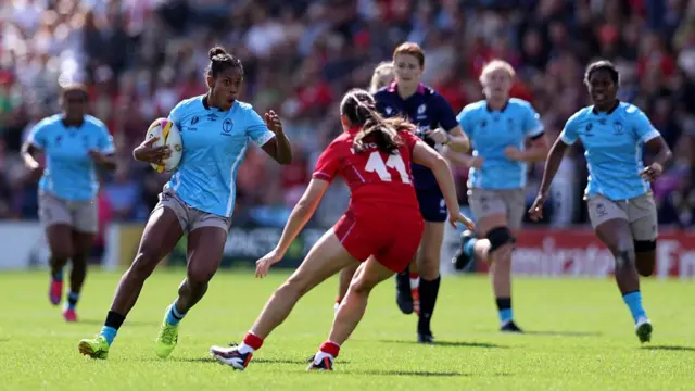 Fiji player runs at Wales defender