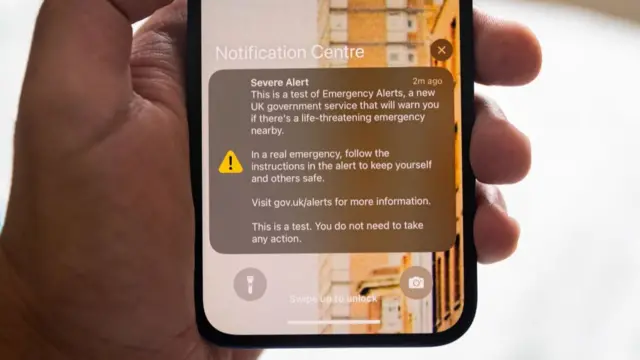 An Emergency Alert from the UK government is shown on the smartphone screen from 2023