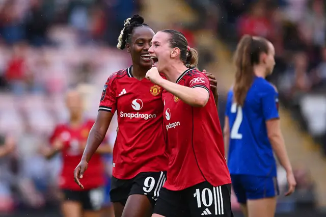 Elisabeth Terland of Manchester United (R) celebrates scoring her team's second goal with teammate Melvine Malard during the Barclays Women's Super League match between Manchester United and Leicester City at Leigh Sports Village