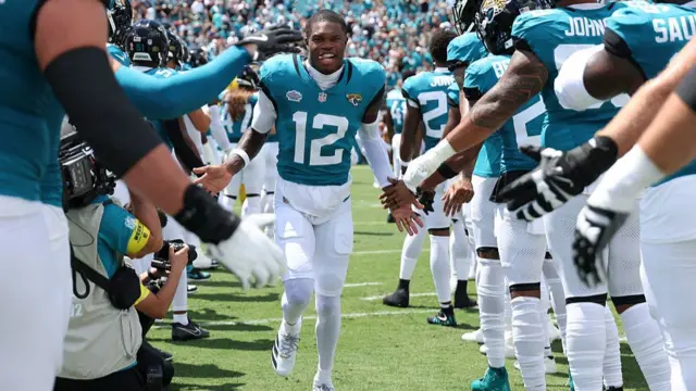 Travis Hunter is welcomed onto the field by his Jacksonville Jaguars team-mates before they play the Carolina Panthers