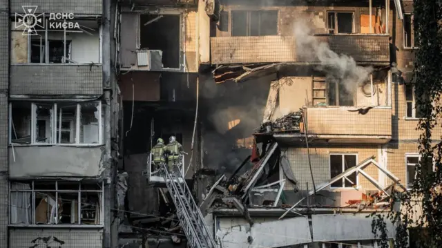 Firefighters outside apartment building where two people were killed by Russian strikes