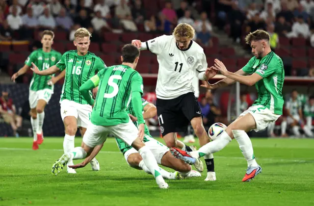 Nick Woltemade of Germany is tackled by Trai Hume and Conor Bradley of Northern Ireland