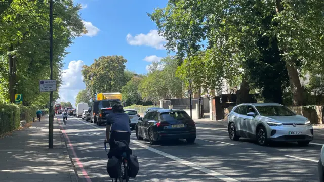 Cars pictured on roads in London, traffic queue goes back quite far.