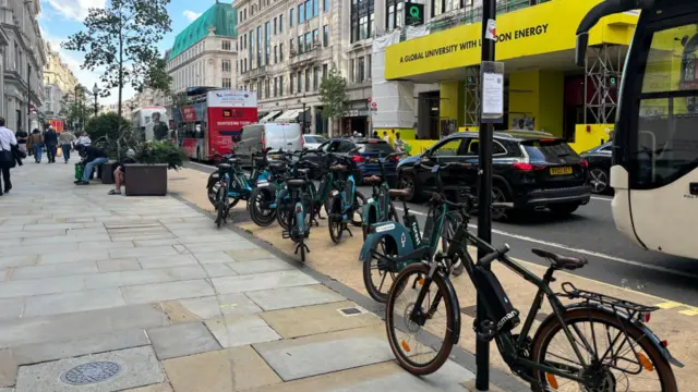 Busy Regents Street in London, traffic at standstill and e-bikes on the pavement.