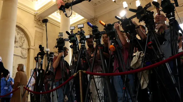 Journalists work in the Salle des Quatre colonnes room before the French Prime Minister faces a confidence vote