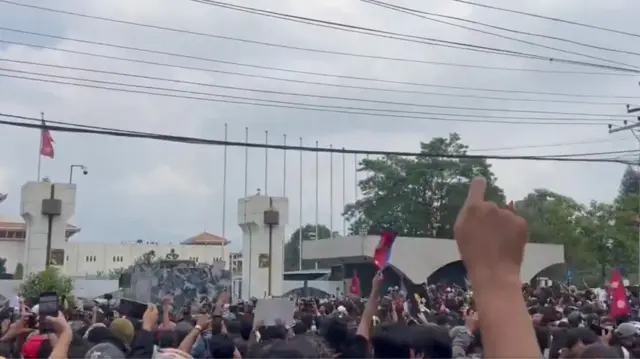 A screengrab from the video showing protesters climbing on to the roof of a gatehouse at the parliament