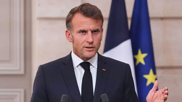 Macron speaks into two microphones set into a lectern