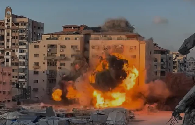 A building mid-explosion with a large fireball at the base
