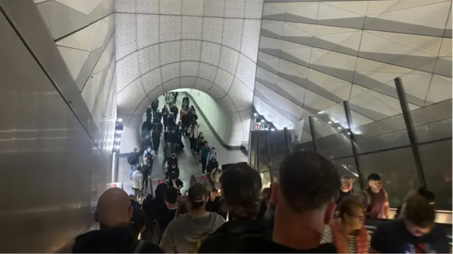 Queues of people on  escalators