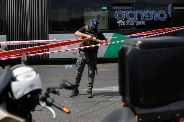 A security personnel stands near the scene where a shooting attack took place at the outskirts of Jerusalem