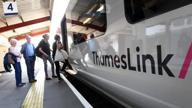 Passengers line up to board a Thameslink service at a train station