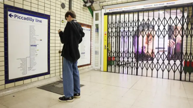 Commuters looks at sign ahead of strikes
