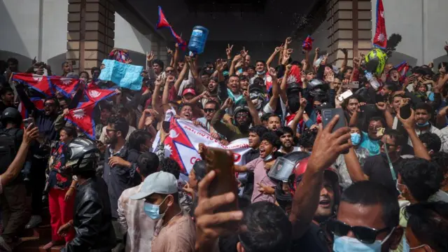 A large group of people holding banners and cheering