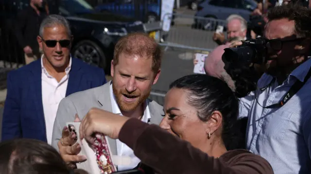 Prince Harry taking a selfie with a woman
