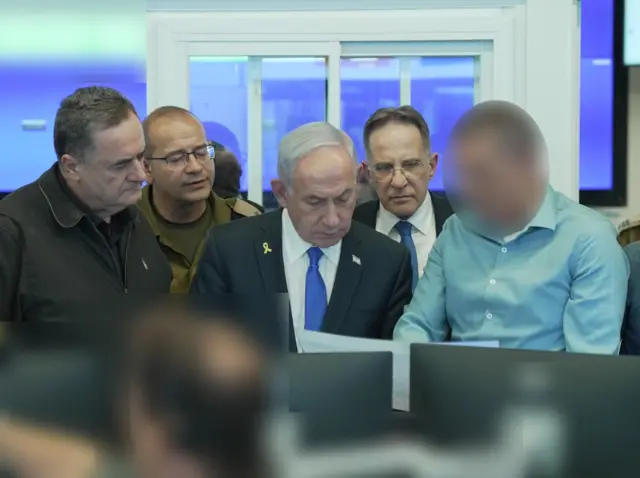 Israeli Prime Minister Benjamin Netanyahu pictured with four other men at the security agency's headquarters. One of the men's faces has been blurred out.