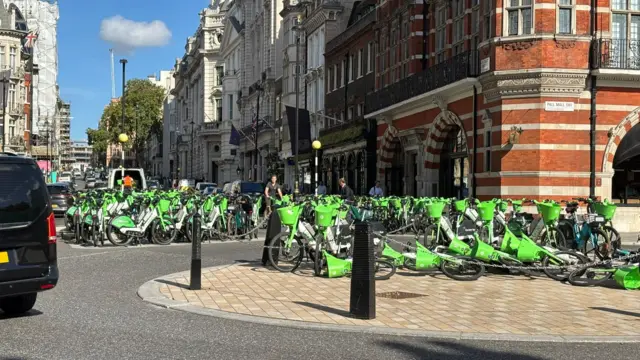 Large amount of lime green bikes parked closely together