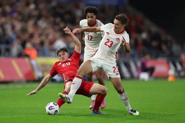 Wales' Dan James tackles Canada's Niko Sigur