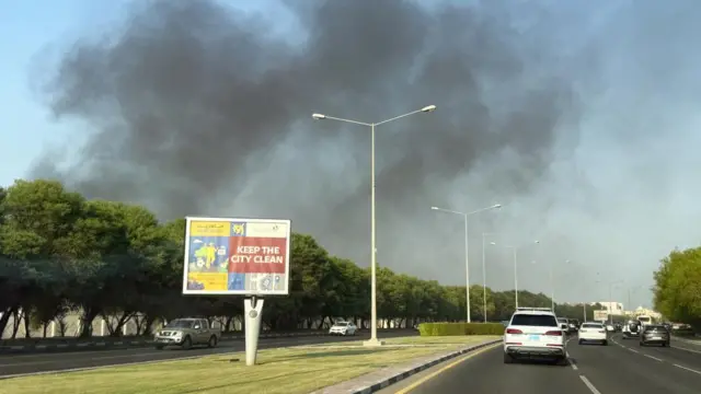 Smoke rising in the sky above a motorway with cars