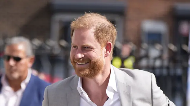 Prince Harry in a grey jacket