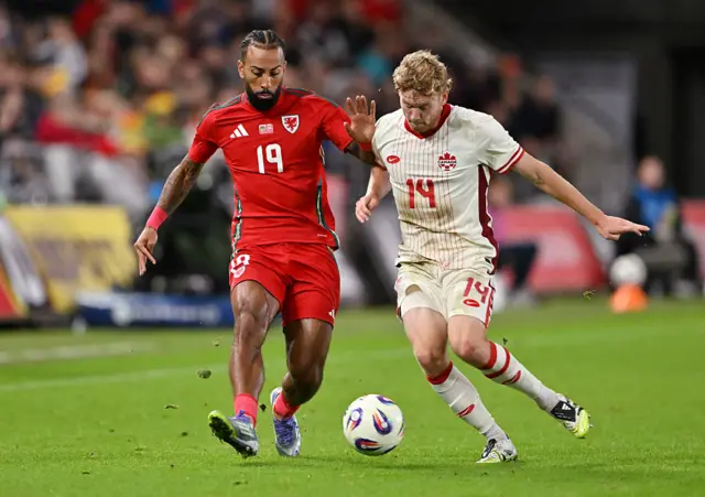 Sorba Thomas of Wales passes the ball whilst under pressure from Jacob Shaffelburg of Canada