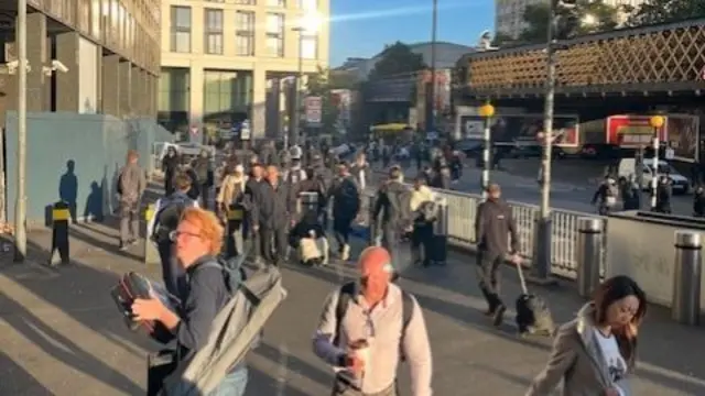 A group of people stand outside Waterloo station