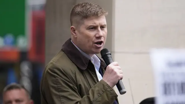 Eddie Dempsey holds a mic