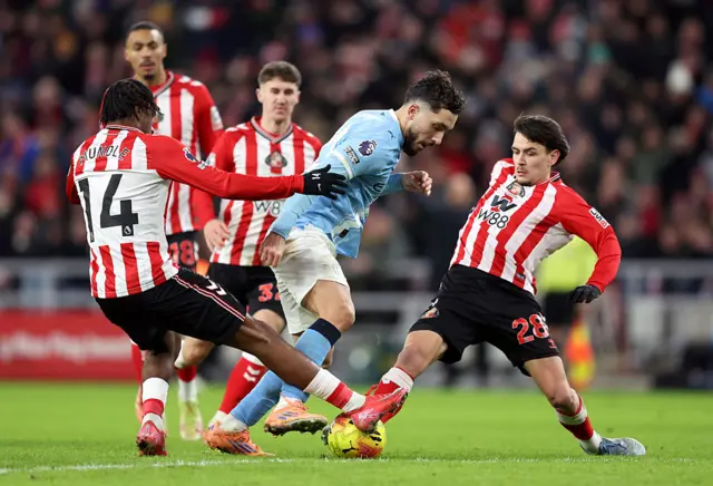 Rayan Cherki of Manchester City is tackled by Romaine Mundle and Enzo Le Fee