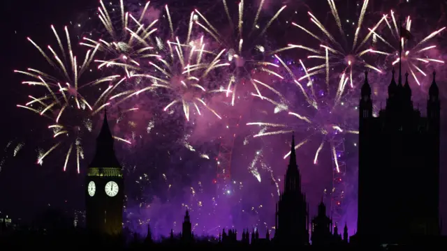 Purple fireworks light up the sky, with Big Ben a silhouette.