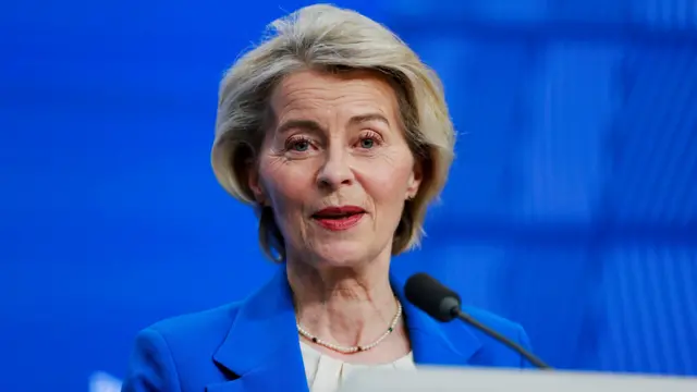Ursula von der Leyen in front of a blue background