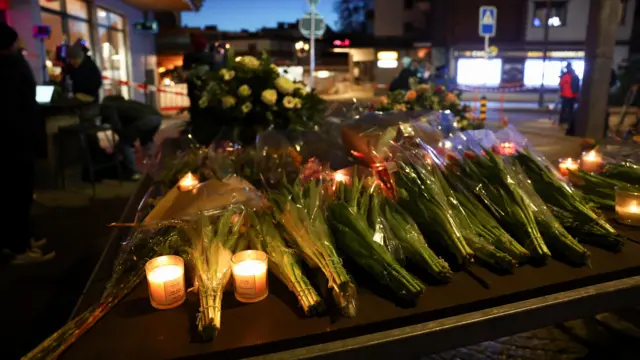 Flowers and candles left near the bar where the fire took place