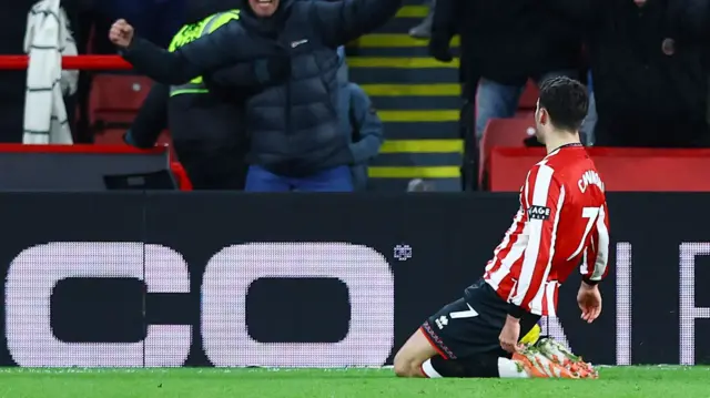 Tom Cannon slides on his knees in celebration in front of fans