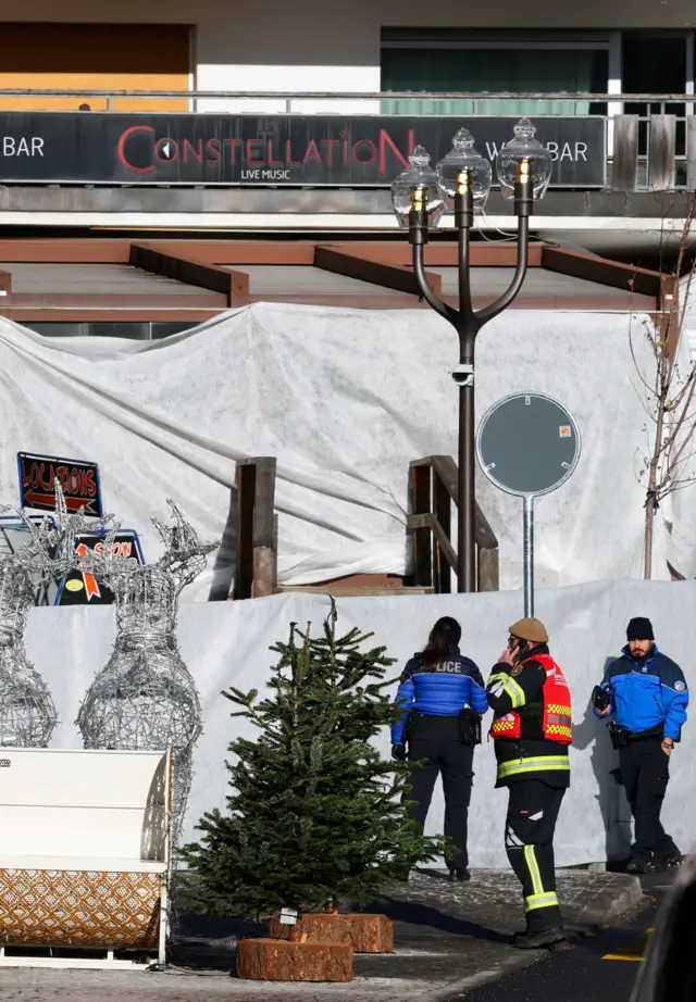 People in hi-vis gear stand outside the bar