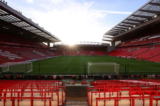 A wide view of Anfield with the sun rising in the distance