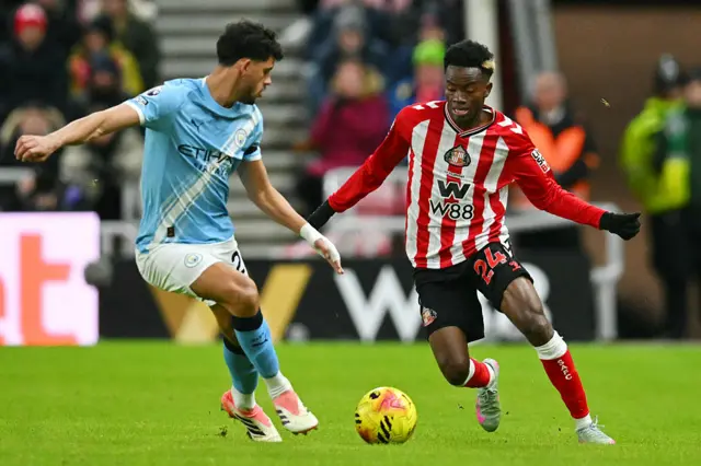 Manchester City's Portuguese midfielder #27 Matheus Nunes (L) challenges Sunderland's English Ivorian #24 Simon Adingra