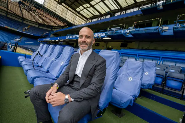 Enzo Maresca sits in the Stamford Bridge dugout during his unveiling as Chelsea head coach