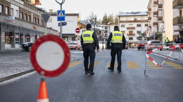 Police officers stand near the site where a fire broke out at Le Constellation bar and lounge following an explosion in the early hours of New Year's Eve, in Crans-Montana, Switzerland, 01 January 2026.