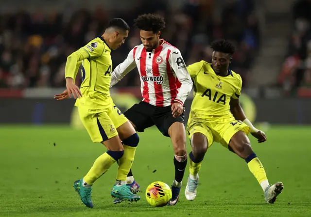 Kevin Schade of Brentford is challenged by Pedro Porro and Mohammed Kudus of Tottenham Hotspur