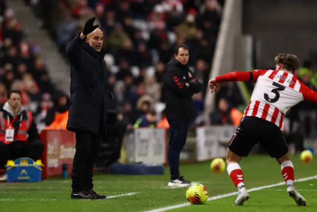 Manchester City manager Pep Guardiola reacts as Sunderland manager Regis Le Bris looks on