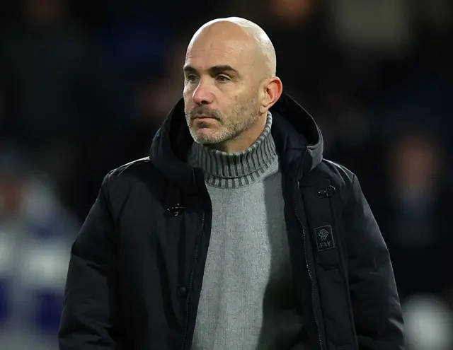 Enzo Maresca wearing a black coat and grey jumper