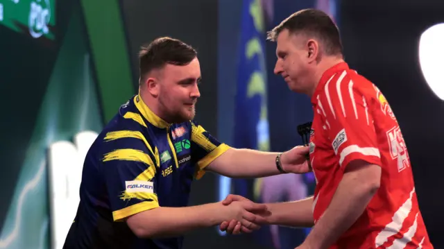 Luke Littler shakes hands with Krzysztof Ratajski