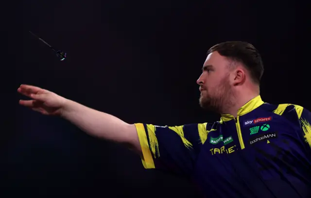 Luke Littler throws a dart